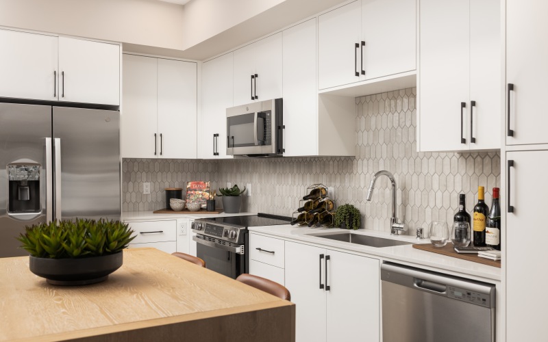 Kitchen with white cabinets and tile backsplash in new apartments in Murrieta, CA at Montessa Heights.