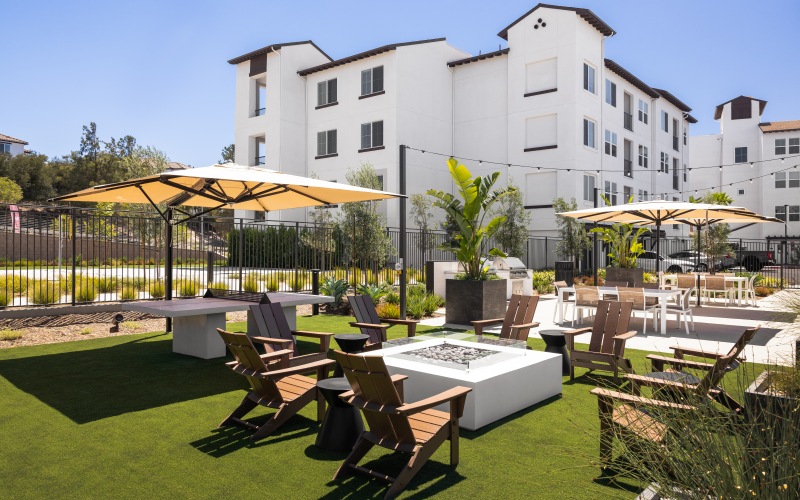 Outdoor area with firepit, ping pong table, BBQ and seating at Montessa Heights apartments in Murrieta.