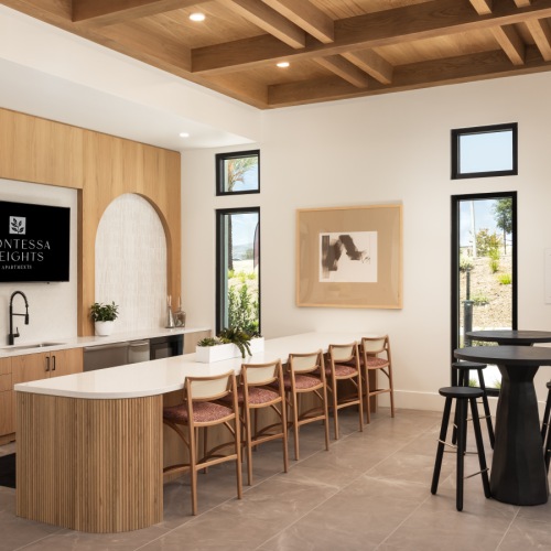 Community kitchen with tables and chairs at Montessa Heights apartments in Riverside County.